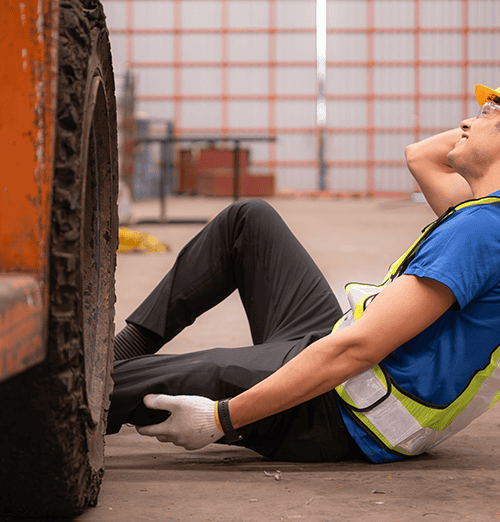 What is a forklift accident? Injured warehouse worker holding his leg beside a forklift